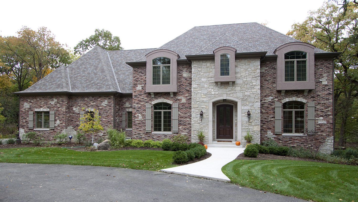 A large brick house with a driveway leading to it