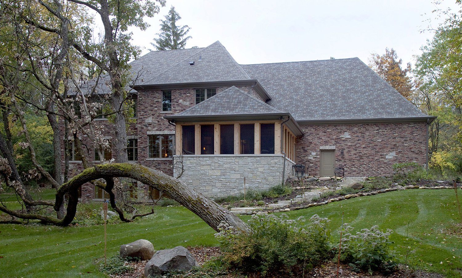 A large brick house with a tree in front of it