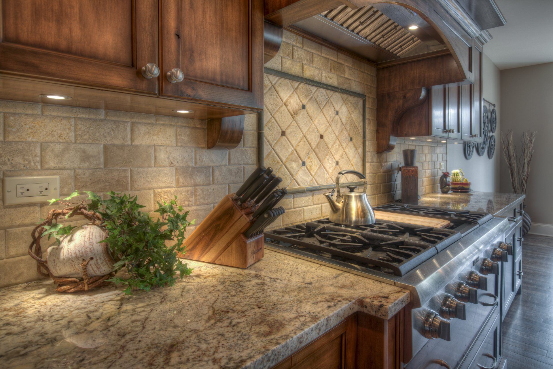 A kitchen with a stove top oven and granite counter tops.