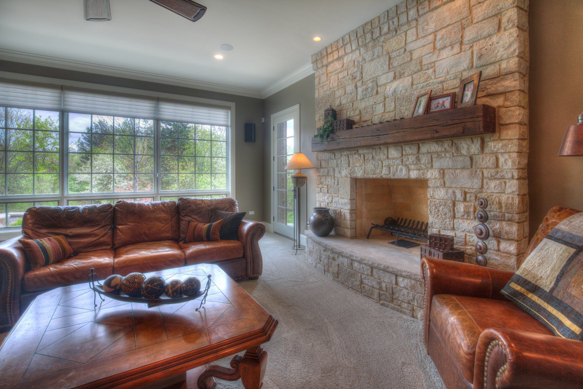 A living room with a couch , chair , coffee table and fireplace.