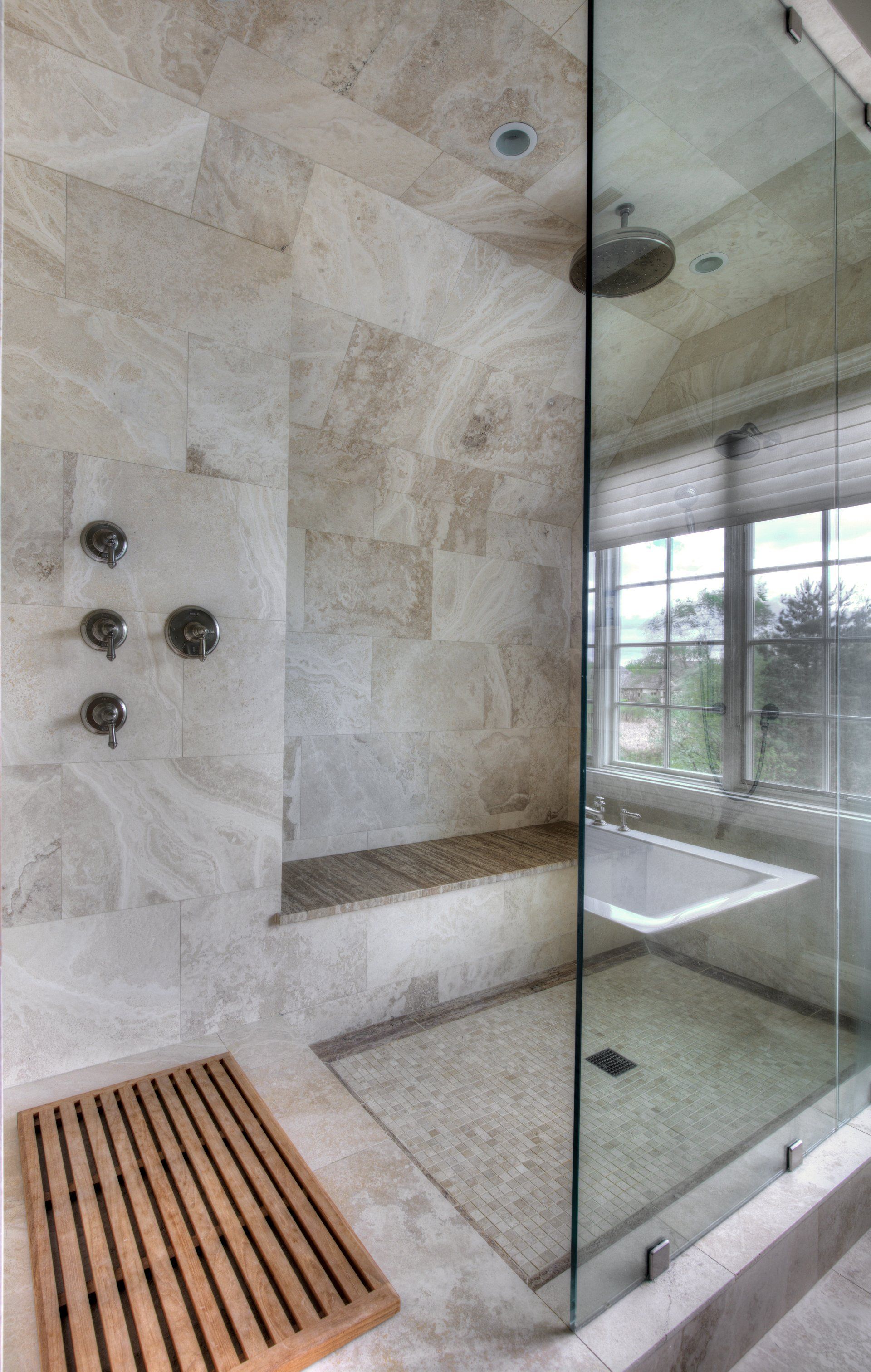 A bathroom with a walk in shower and a bathtub.