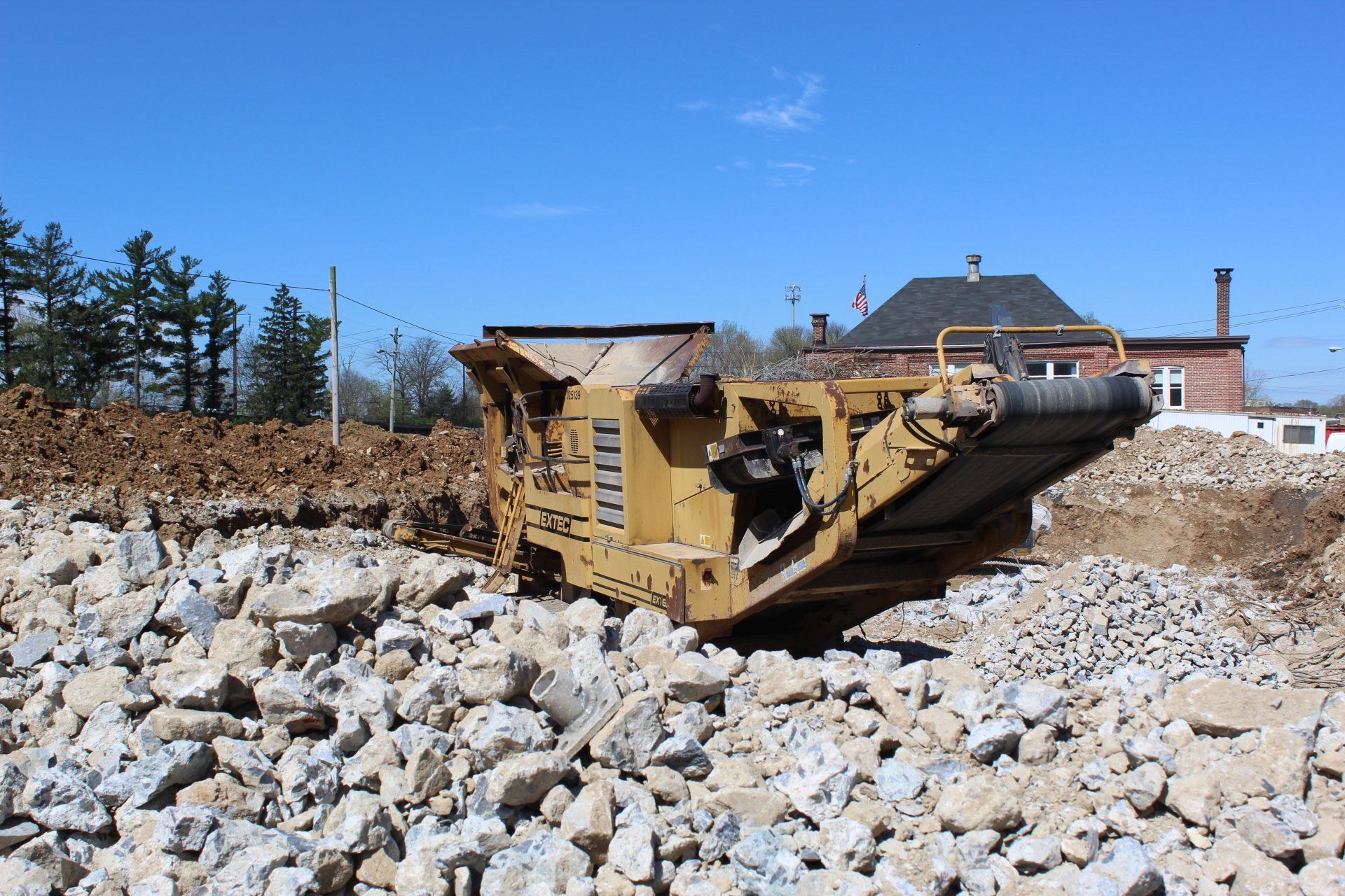 A large machine is sitting on top of a pile of rocks.