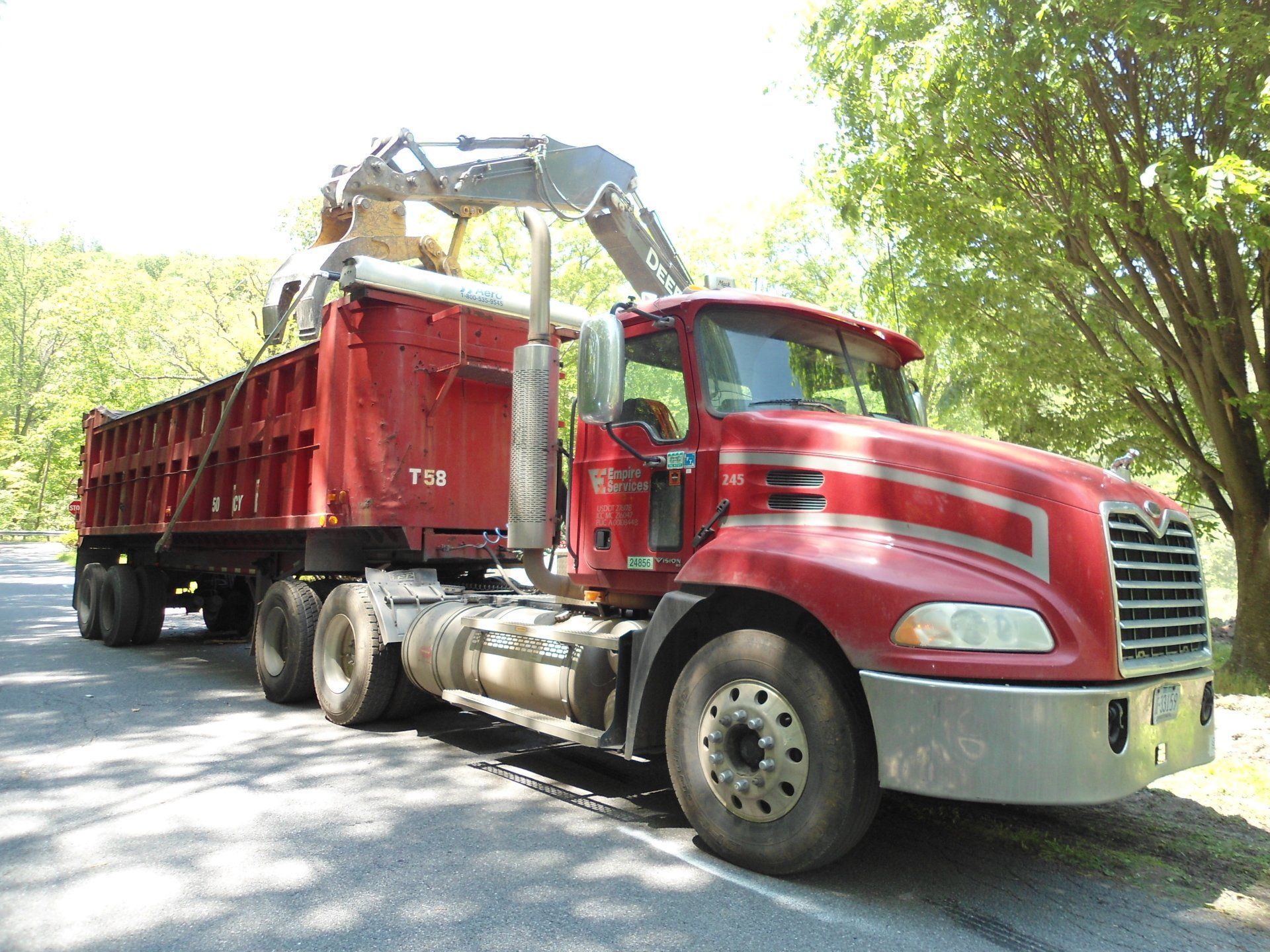 A red dump truck is parked on the side of the road
