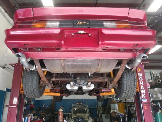 Undercar view of red classic car with new exhaust installed - Lou's Custom Exhaust of Worcester