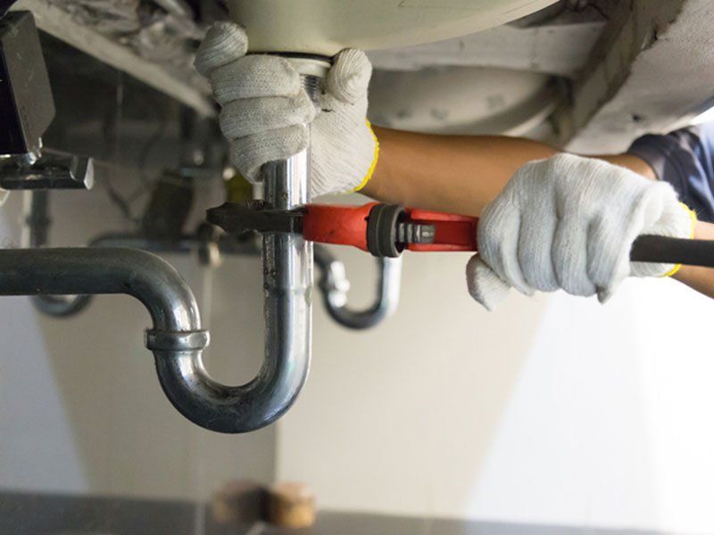 Plumber Fixing White Pipe — Martinez, CA — Ernie’s Plumbing & Sewer Service Plumber Fixing White Pipe — Martinez, CA — Ernie’s Plumbing & Sewer Service