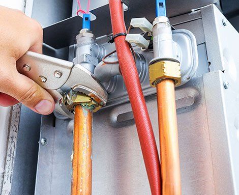 Plumber Repairing a Gas Boiler — Martinez, CA — Ernie’s Plumbing & Sewer Service Plumber Repairing a Gas Boiler — Martinez, CA — Ernie’s Plumbing & Sewer Service