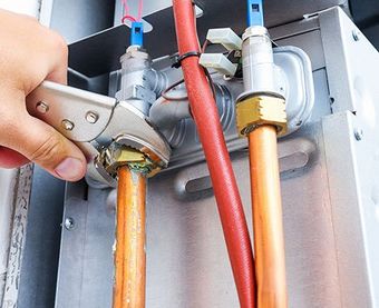 Plumber Repairing a Gas Boiler — Martinez, CA — Ernie’s Plumbing & Sewer Service Plumber Repairing a Gas Boiler — Martinez, CA — Ernie’s Plumbing & Sewer Service