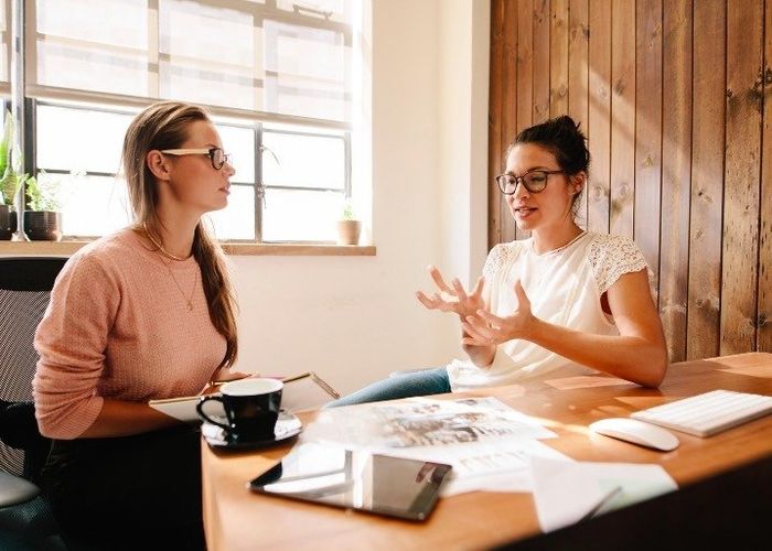Two women talking, one explaining something to the other