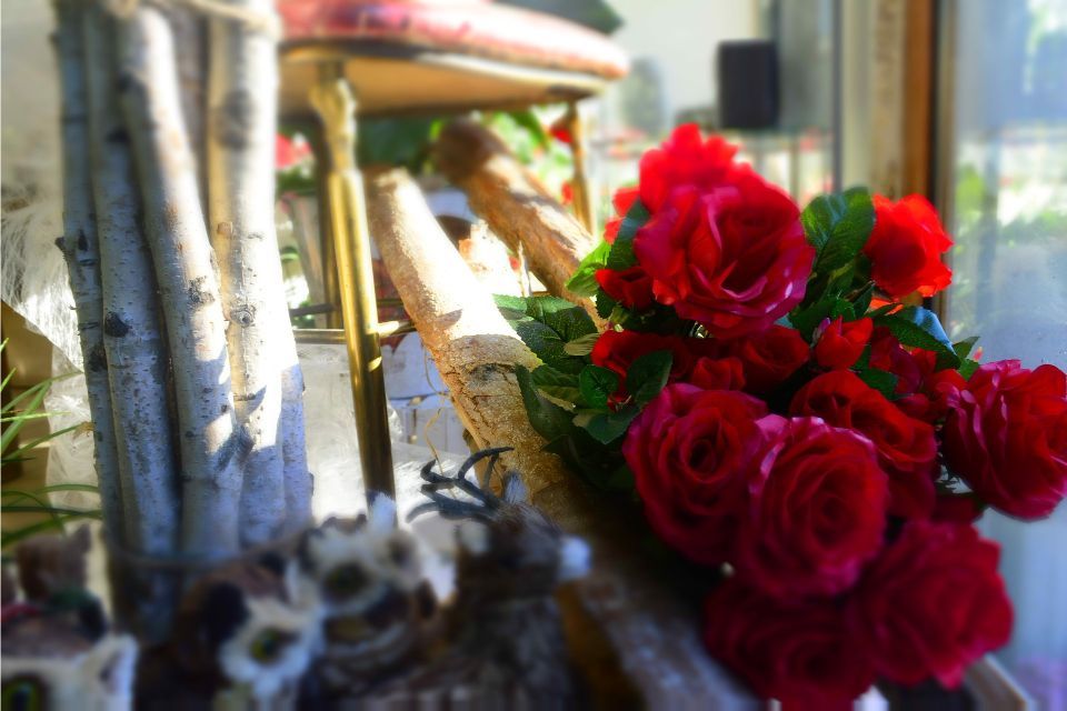 Rose rosse in un bouquet che nascondono parzialmente una sedia di legno.