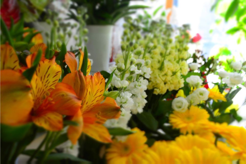 Fiori dai colori vivaci, tra cui gigli arancioni e gerbere gialle, in un negozio di fiori.