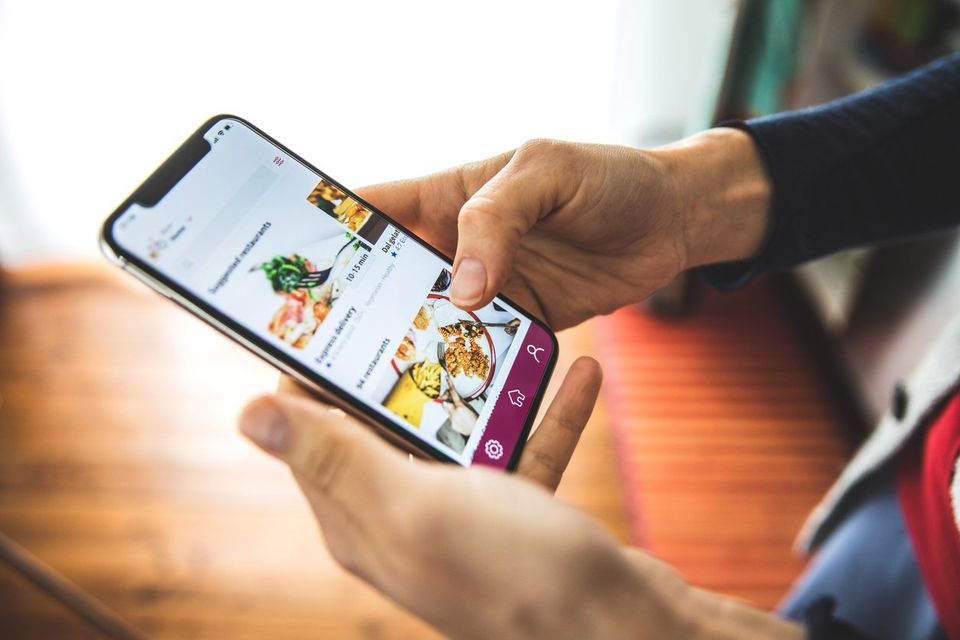 Person ordering food online using an online ordering platform on a mobile phone.