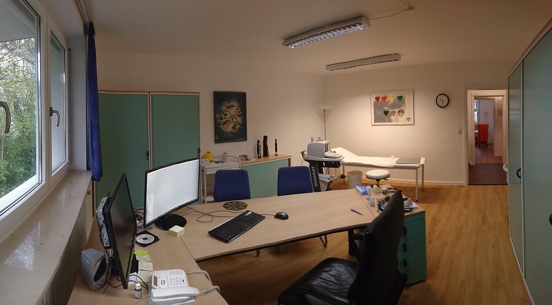 Ein Raum mit einem Schreibtisch und zwei Computermonitoren
