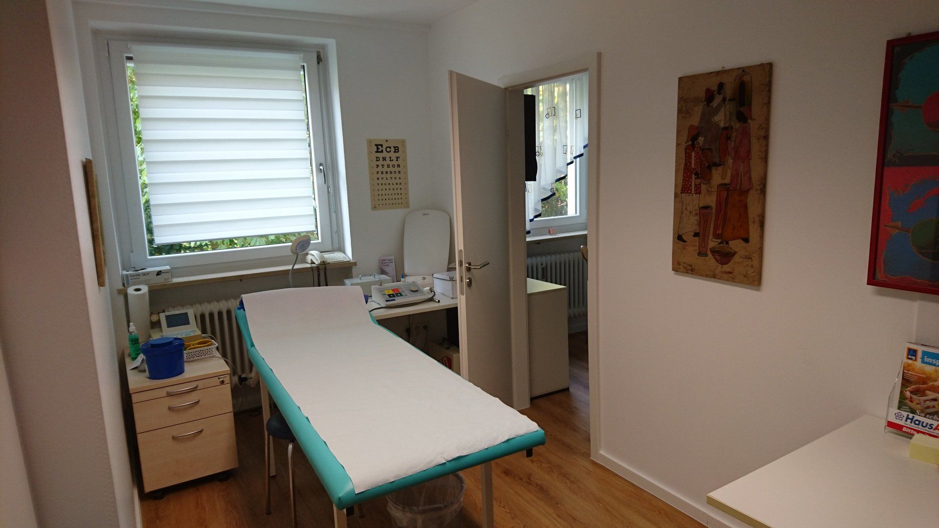 Eine Arztpraxis mit einem Tisch und einem Fenster.