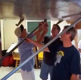 A man wearing a statue of liberty shirt is working on a table
