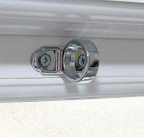 Chrome curtain rod bracket attached to a white wall/trim
