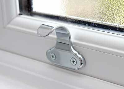 White window latch on a white frame beside frosted glass