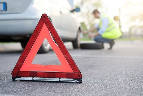 Roadside Assistance — Man changing one flat tyre after vehicle breakdown in Redding, CA 96001