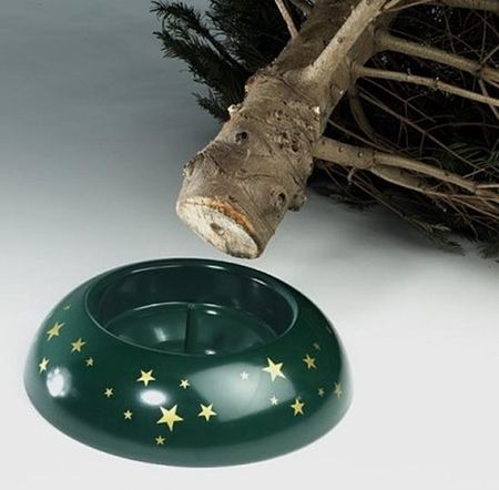 dunkelgrüner Stand mit Sternen mit Stamm von einem Tannenbaum der über dem Ständer liegt