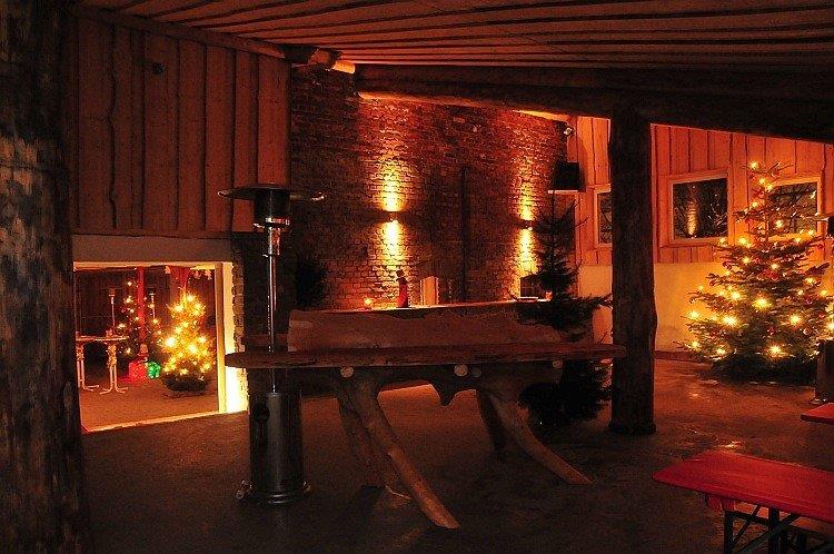 Eine große Scheune, beleuchtet und mit Weihnachtsbäumen dekoriert