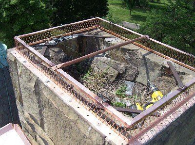 Chimney with copper mesh screen, drilled fasteners, and a yellow drill on the top.