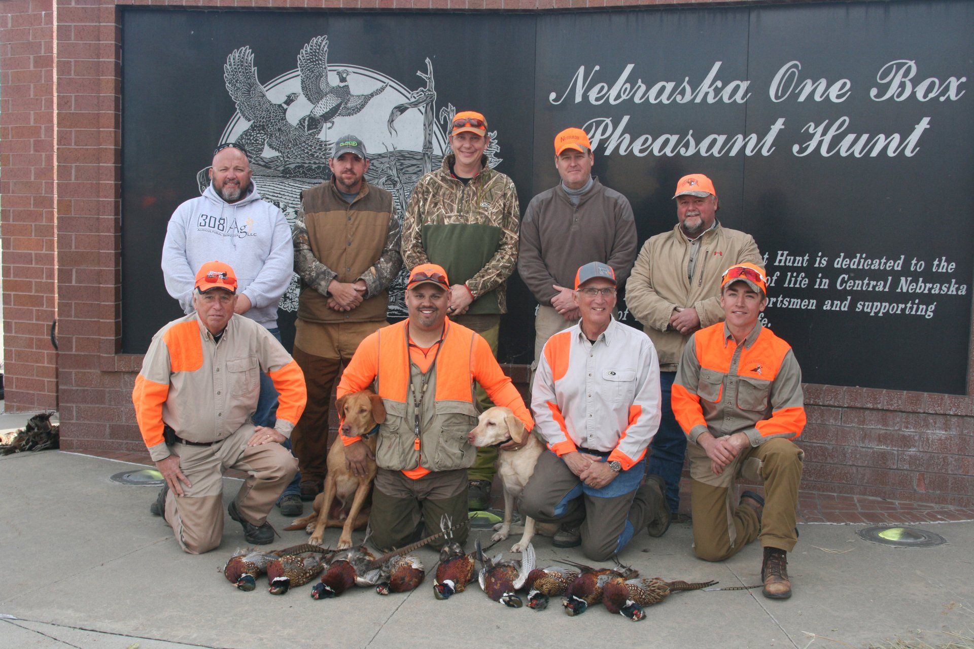 Group of hunters posing with pheasant at the Nebraska One Box Pheasant Hunt.