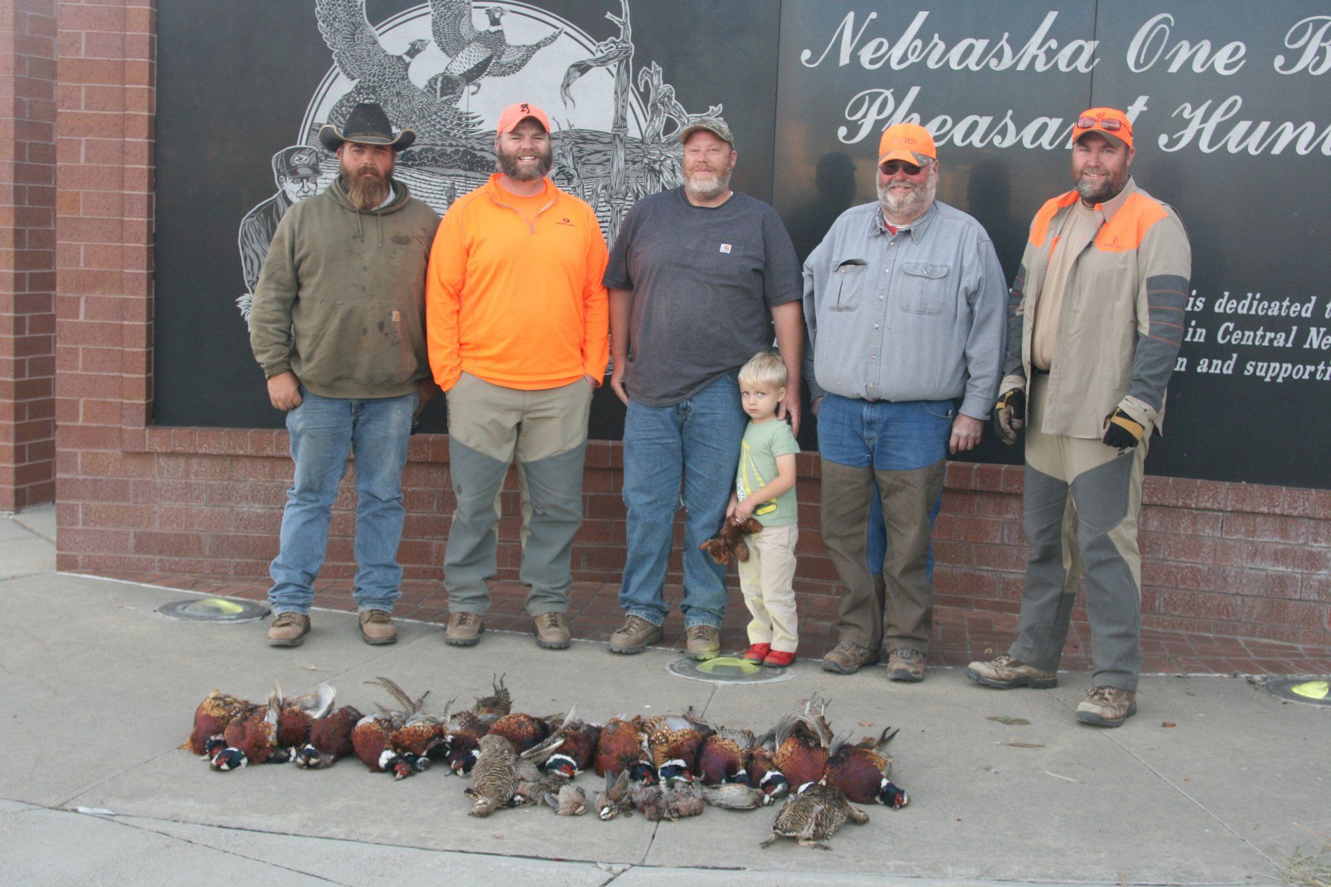 Group of pheasant hunters pose with their harvest in Nebraska.