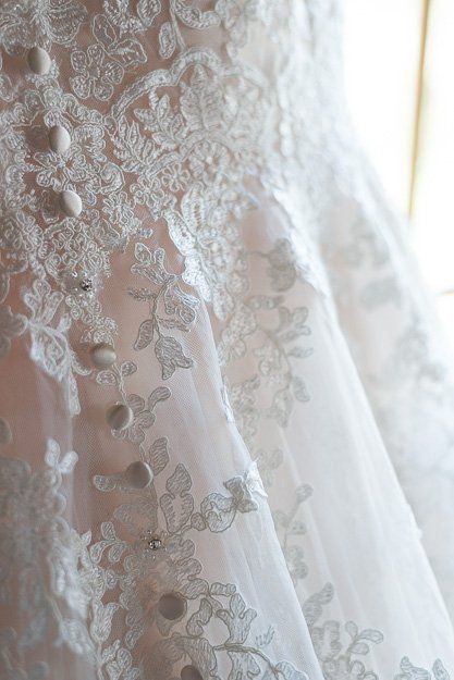 a close up of a wedding dress with buttons on it .