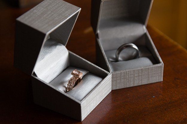a ring and a wedding ring are in boxes on a table .