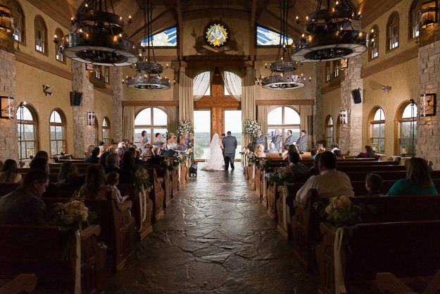 a bride and groom are walking down the aisle of a church .