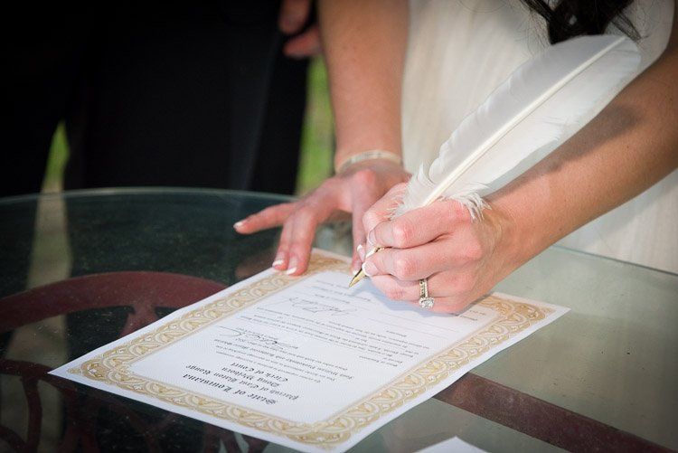 a woman signing a document with a feather pen