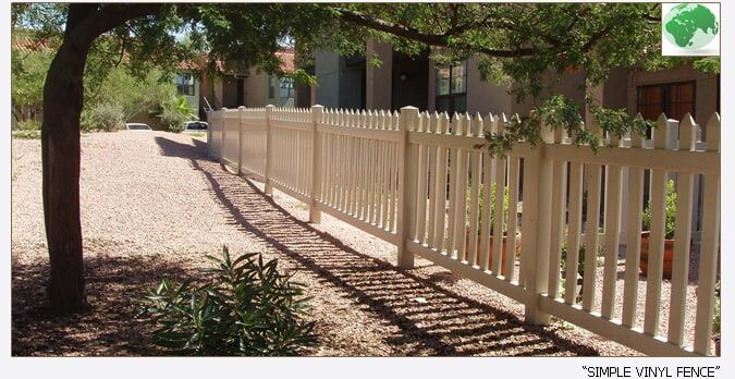 White picket vinyl fence in a residential area, under a tree, creating a property border.