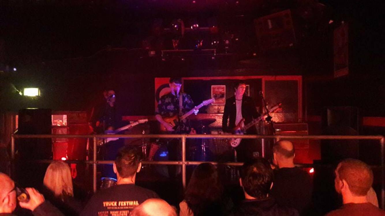 A group of people watching a band on stage in a dark room