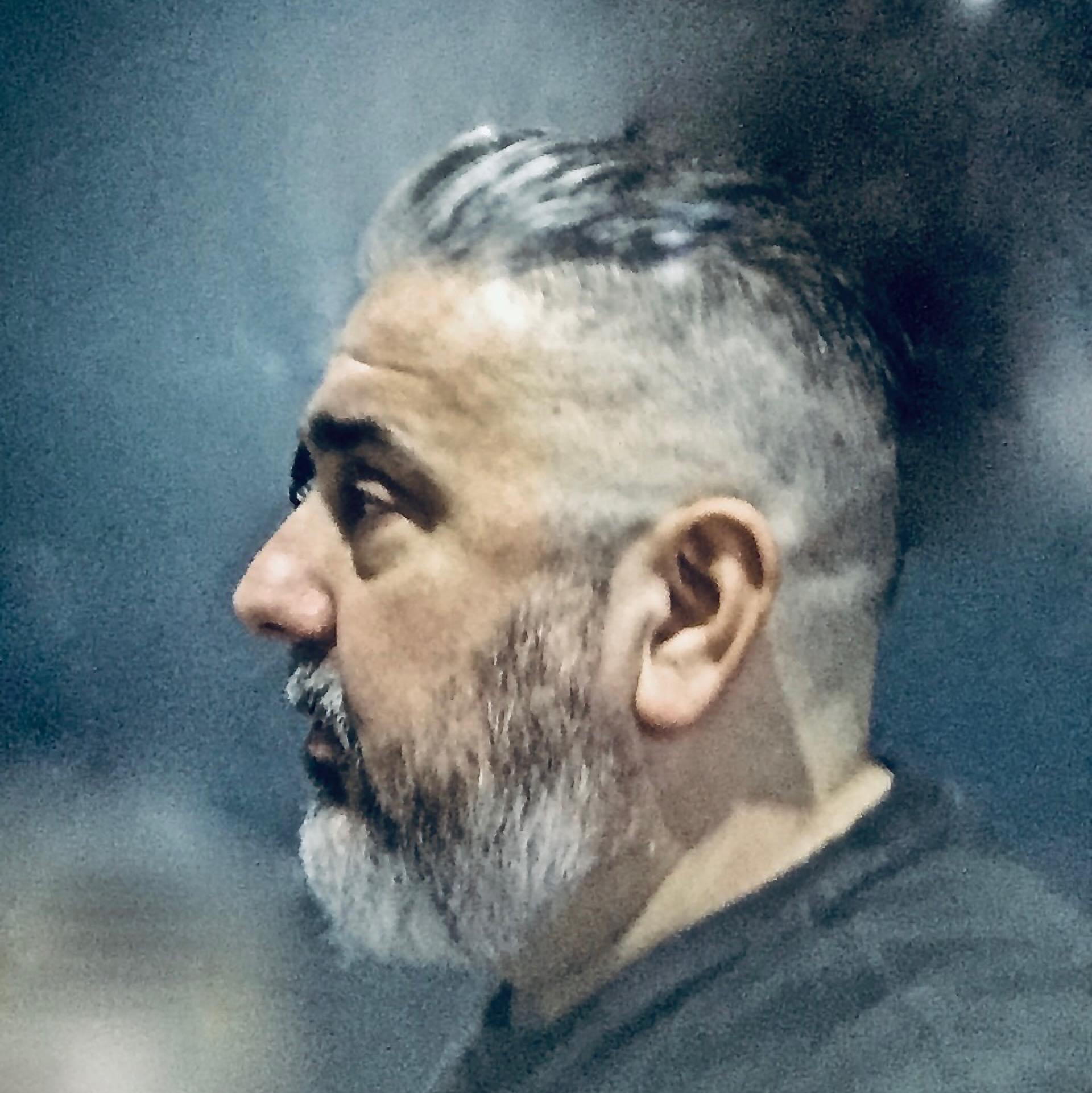 A man with a beard is wearing a black shirt.