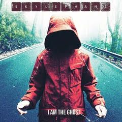 A person in a red jacket with a hood is standing on a road.