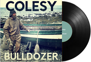 A man standing next to a boat on the cover of colesy bulldogzer