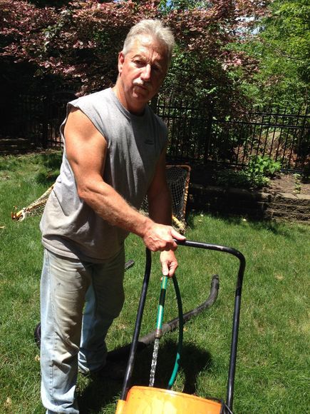 A man is standing in the grass holding a rake
