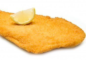 Fried fish fillet with a lemon wedge on top.