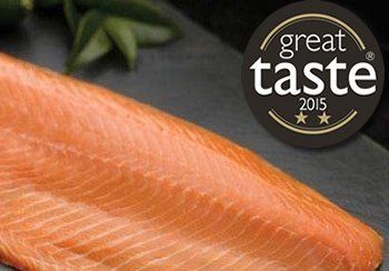 Smoked salmon fillet, reddish-orange, on dark slate, with