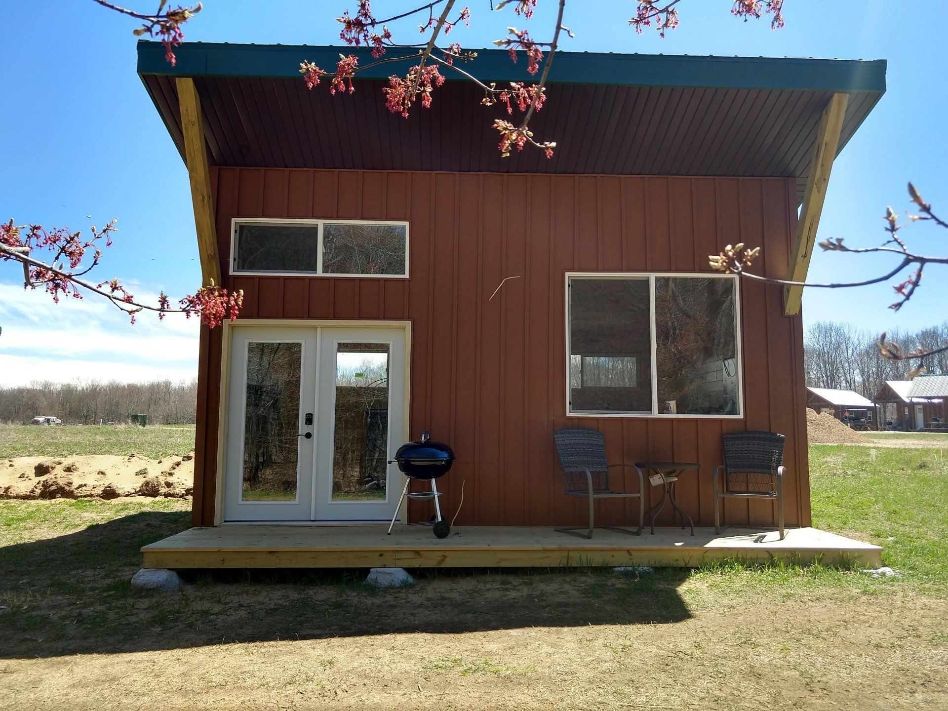 Front view of our couples cabin featuring a porch, large windows and french doors