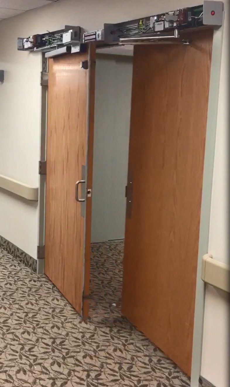 Two wooden doors are open in a hallway.