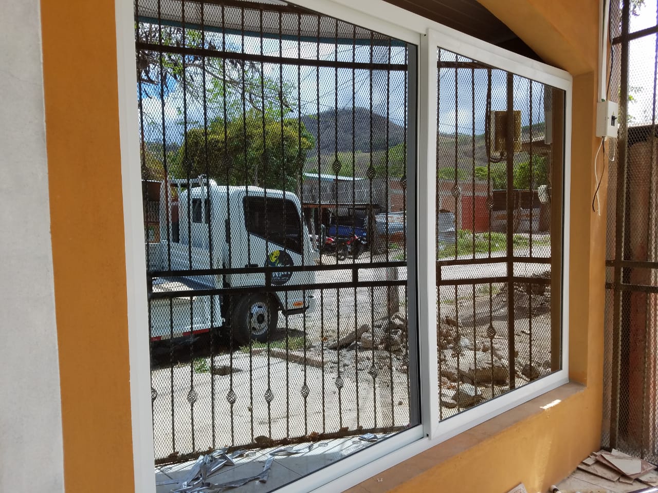 Instalación de portón eléctrico residencial con acabado estilo madera en Nicaragua