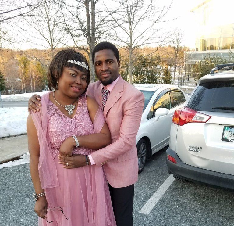 A man in a pink suit is hugging a woman in a pink dress