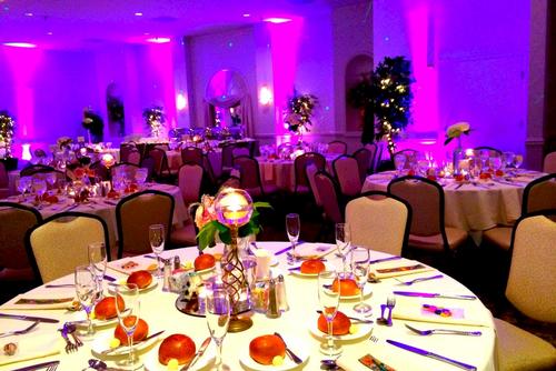A large room with tables and chairs set up for a wedding reception.