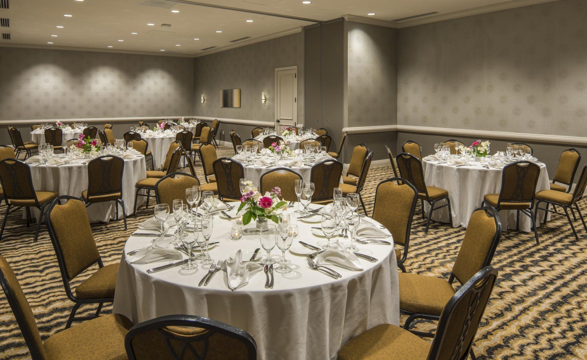 A large room with tables and chairs set up for a banquet.