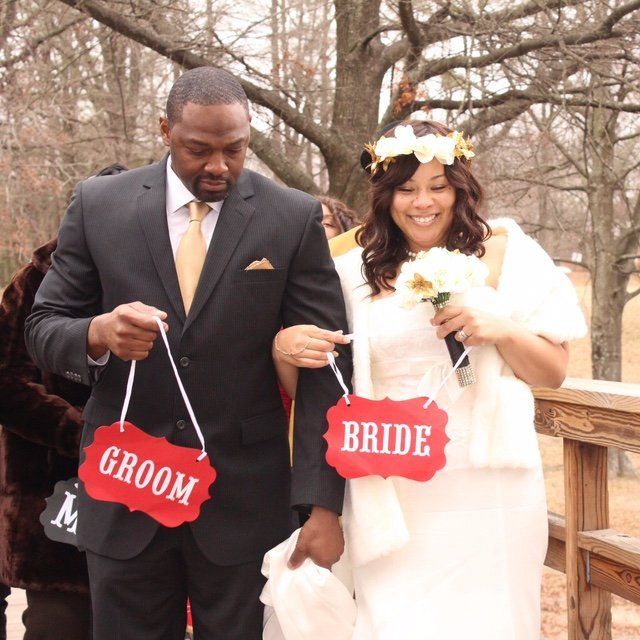 A bride and groom holding signs that say groom and bride