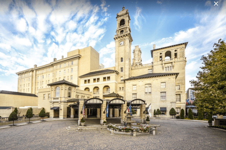 A large building with a clock tower in front of it