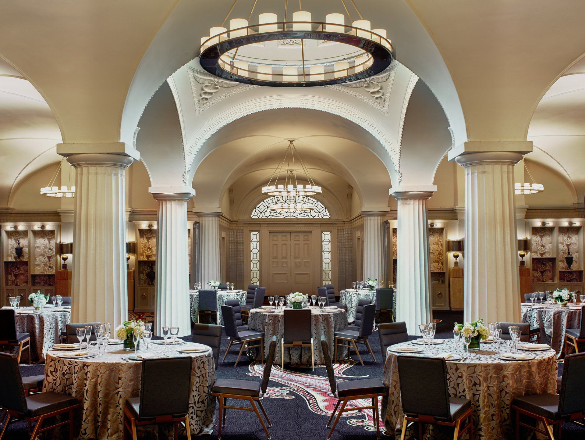 A large room with tables and chairs and a chandelier