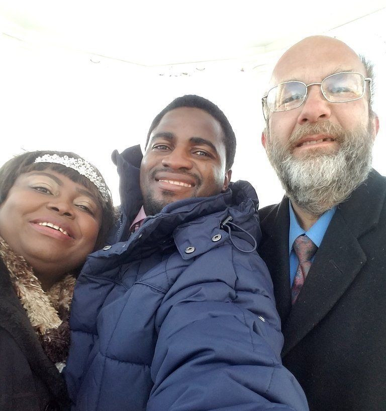 Two men and a woman are posing for a picture together