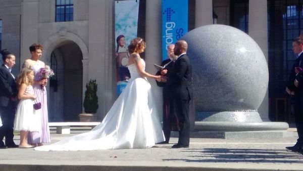 A bride and groom hold hands during their wedding ceremony