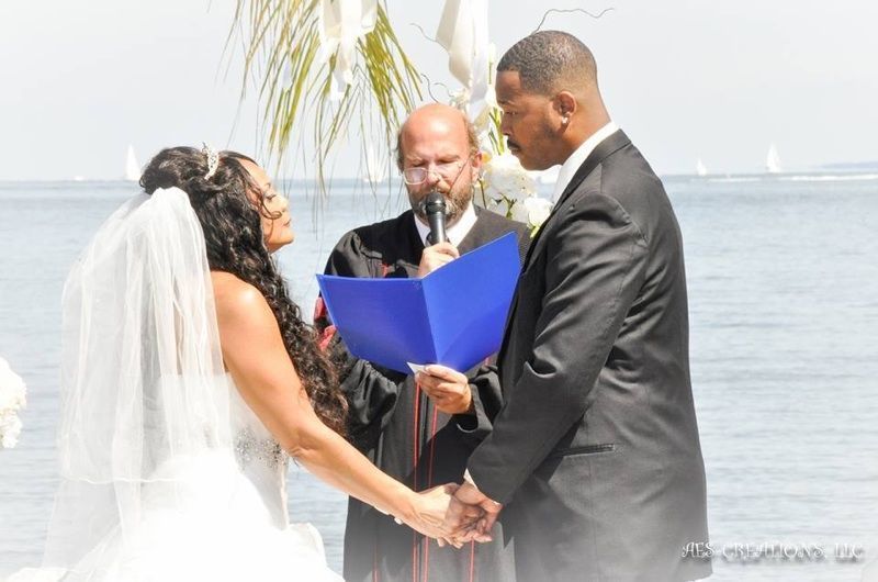 A bride and groom hold hands during their wedding ceremony